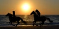 Two horse riders galloping on the beach Royalty Free Stock Photo