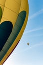 Two hot air balloons flying in the blue sky. One in close detail and one far away Royalty Free Stock Photo