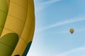 Two hot air balloons flying in the blue sky. One in close detail and one far away Royalty Free Stock Photo