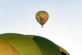 Two hot air balloons flying in the blue sky. One in close detail and one far away Royalty Free Stock Photo