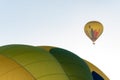 Two hot air balloons flying in the blue sky. One in close detail and one far away Royalty Free Stock Photo