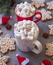 Two hot chocolate cups and marshmallows , against grey background & Christmas composition with Snowflake gingerbread cookies Royalty Free Stock Photo