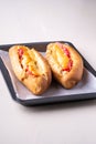 Two hot dog fast food junk fresh sausage cheese sauce isolated on baking tray white background Royalty Free Stock Photo