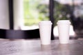 Two hot paper cups of espresso coffee on table in cafe restaurant Royalty Free Stock Photo