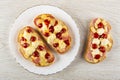 Hot sandwiches with sausage, cheese, ketchup and mayonnaise in plate, uncooked sandwich on table. Top view