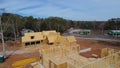 Two houses under construction with building envelope and wooden frame beam, joist, trusses framework, gable roof in suburban area