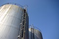 Two huge industrial silos against a blue sky Royalty Free Stock Photo