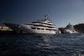Two huge yacht in port of Monaco at sunset, glossy board of the motor boat, the chrome plated handrail, megayacht is