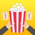 Two human businessman hands holding big popcorn box. Two Tickets with stars. Movie Cinema icon in flat design style. Pop corn. Fas