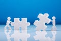 Two Human Figures Solving Jigsaw Puzzle Royalty Free Stock Photo