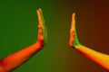 Two human hands gesturing  on green studio background in neon light. Concept of human relation, community Royalty Free Stock Photo