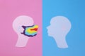 Two human profiles cut out of paper and profile on the left is in a rainbow mask Royalty Free Stock Photo