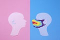 Two human profiles cut out of paper and profile on the right is in rainbow mask Royalty Free Stock Photo