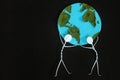 Two human stick figure man carrying the earth on shoulders on dark black background. Save planet earth together, teamwork Royalty Free Stock Photo