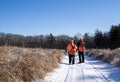 Two Hunters Walk Along A Road Watching For Birds