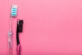 Two hygienic toothbrushes on a pink background. Copy space