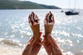 Two ice cream cones with chocolate and jam in a female hand Royalty Free Stock Photo