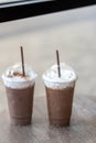 Two iced chocolate or mocha coffee in take away glass topped with milk foam cream Royalty Free Stock Photo