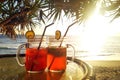 Two iced tea cocktails on table on background of palm trees at sunset Royalty Free Stock Photo