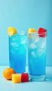 Two icy blue drinks, red yellow ice cubes, light blue background, bright, refreshing drinks Royalty Free Stock Photo