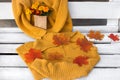 Two identical knitted bright yellow sweaters, autumn maple leaves, a bouquet of garden flowers in a craft bag Royalty Free Stock Photo