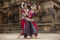 Two Indian classical odissi dancers striking a pose in front of Mukteshvara Temple,Bhubaneswar, Odisha, India