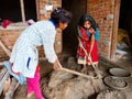 two indian female worker mixing bbuilding material together at incomplete house in India dec 2019