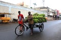 Two Indian men are helping to haul a banana truck on the road in the Pondicherry city
