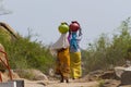 Two Indian women carry water on their heads in