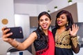 two indian women in saree talk with family by phone video chatting at living room in home Royalty Free Stock Photo