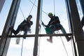 Two industrial climbers wash the windows in the apartment, the view from the inside