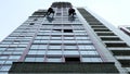 Two industrial climbers are washing, cleaning facade of a modern office building Royalty Free Stock Photo