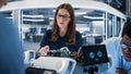 Two Industrial Robotics Engineers Gathered at a Table With Robotic Mobile Prototype. Two Females