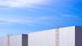 Two Industrial Warehouse Buildings with cylinder ladder on Aluminium corrugated wall against blue sky Background Royalty Free Stock Photo