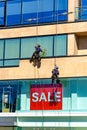 Two industrial window cleaners on tall building