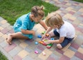 two inquisitive boys, friends, brothers of preschool age play with a puzzl Royalty Free Stock Photo