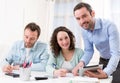 Two interns working together assisted by their course supervisor Royalty Free Stock Photo