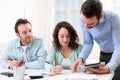 Two interns working together assisted by their course supervisor Royalty Free Stock Photo