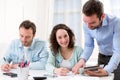 Two interns working together assisted by their course supervisor Royalty Free Stock Photo