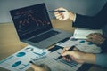 Two investors working together are analyzing the stock chart on the computer screen at the company