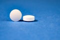White round pharmaceutical pills on blue background Royalty Free Stock Photo