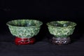 Two Jade bowls with wooden base isolated on dark background