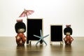 Two Japanese dolls with two blank black board with blue star fish and red umbrella Royalty Free Stock Photo