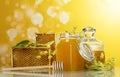 Two jars of honey, Linden flowers, wooden frames with honeycomb on yellow background Royalty Free Stock Photo