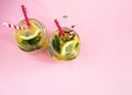 Two jars of tasty cold lemonade on a pink background. View from above