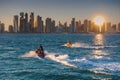 Two jet-skis cruising with the skyline of West Bay in background, at sunset. Doha, Qatar. Royalty Free Stock Photo