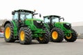 Two John Deere 6210R Agricultural Tractors on a Yard.