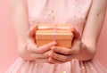 two joined hands holding a golden gift box with glittering ribbons, symbolizing gratitude and affection, human connection through