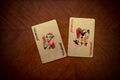 Two jokers on the table, two playing cards, golden playing cards on wooden background, gold cards next to each other Royalty Free Stock Photo