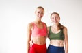 Two joyful lovely happy women of different ages having fun together on yoga training, broadly smiling on camera during workout Royalty Free Stock Photo